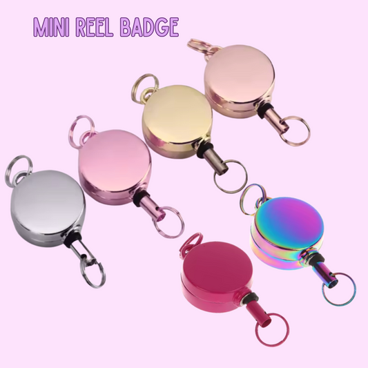 Mini reel badge holder in various colors on a pink background