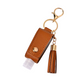 Brown leather keychain with tassel and small bottle on a white background