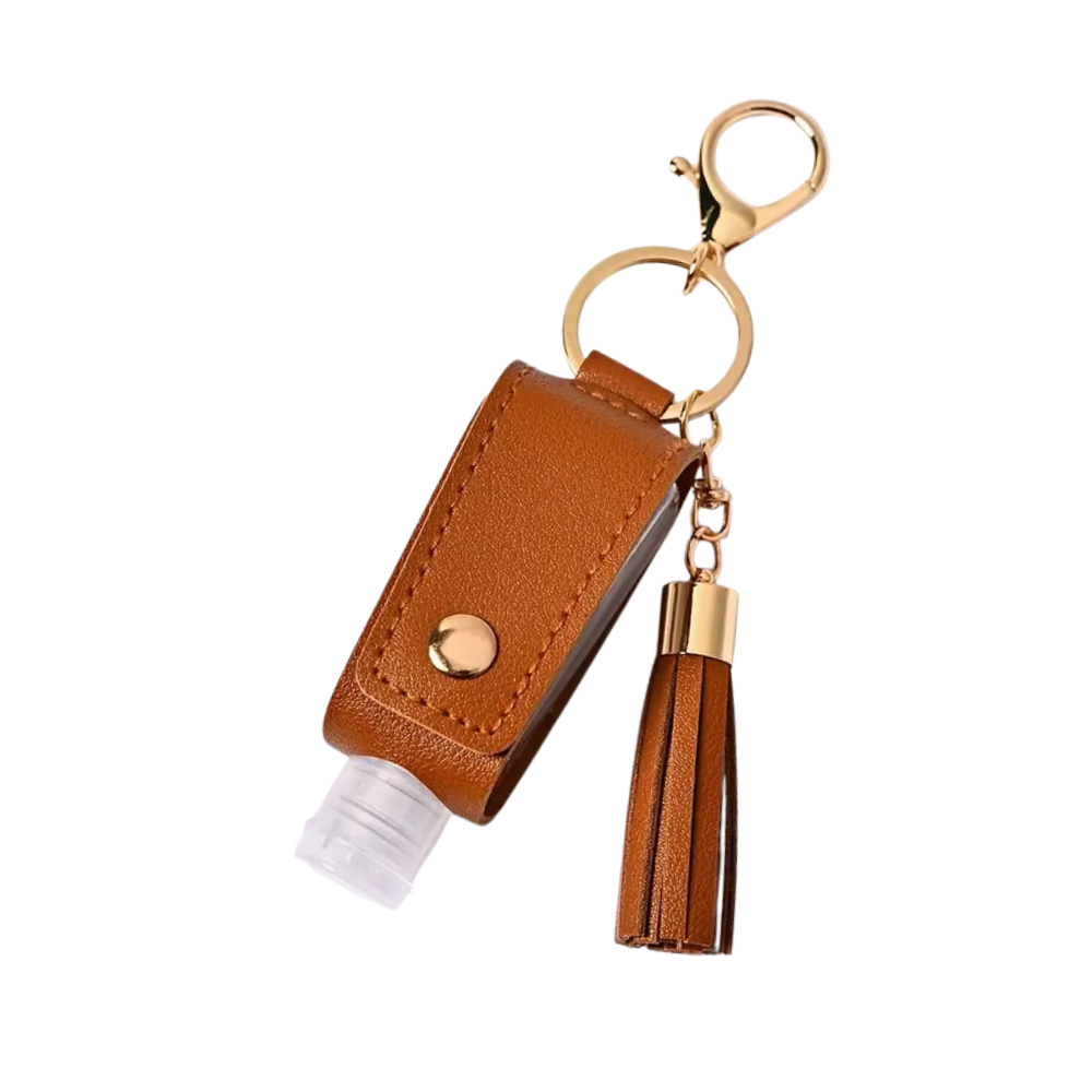 Brown leather keychain with tassel and small bottle on a white background