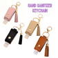 Hand sanitizer keychains with tassels in pink, beige, black, and brown on a white background.