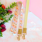 Reversible lanyard with floral and checkered patterns on a soft pink background with strawberries and leaves.