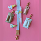 Collection of small accessories including hair clips, a pen, and keychains on a pink background