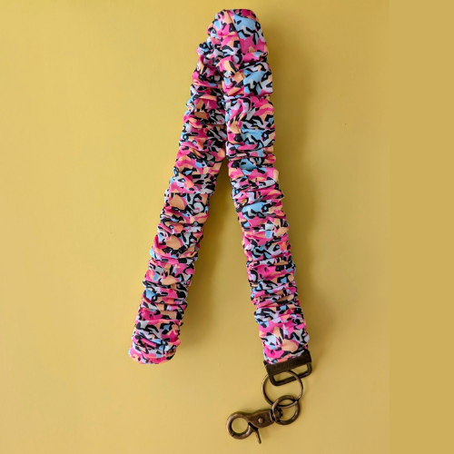 Colorful camouflage-patterned lanyard with a key ring on a yellow background