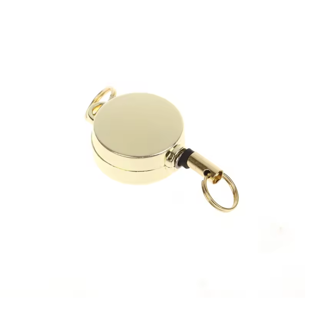 Gold-colored metal reel with a keychain on a white background