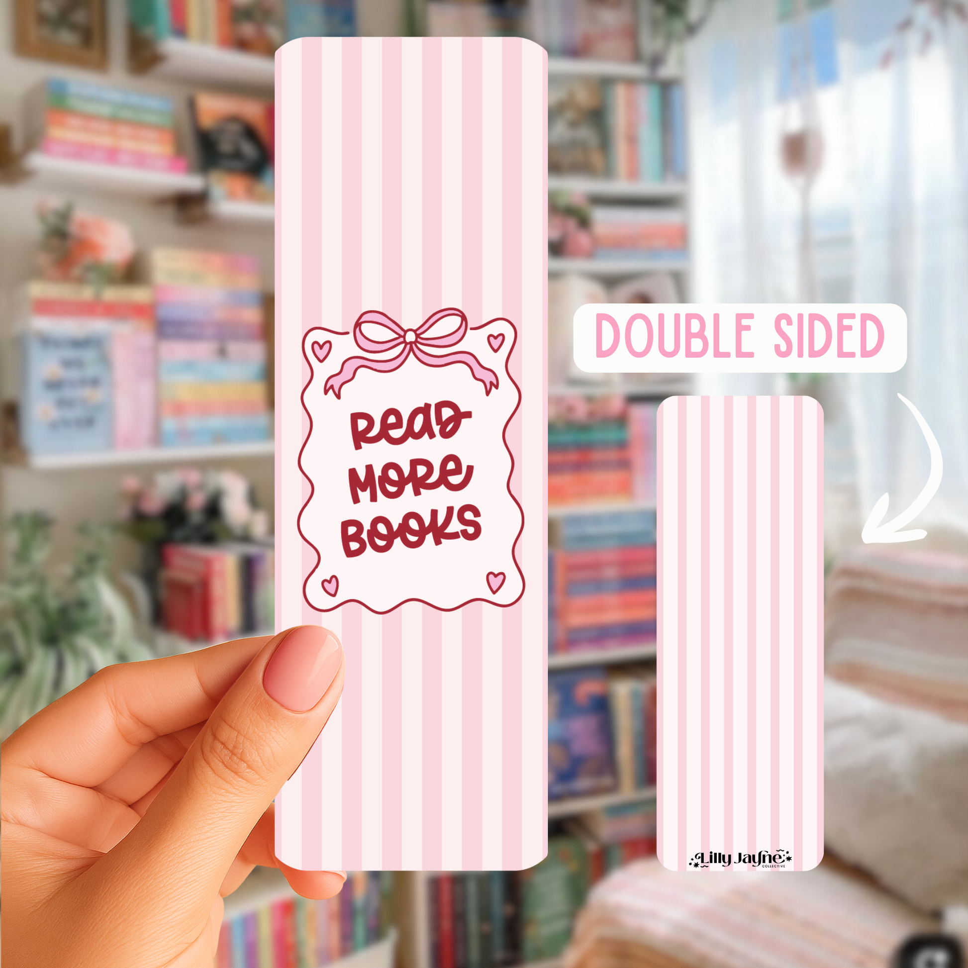 Pink bookmark with 'Read More Books' text held by a hand in front of a bookshelf.