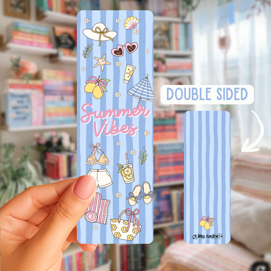 Double-sided bookmark with summer-themed illustrations held by a hand in front of a bookshelf.