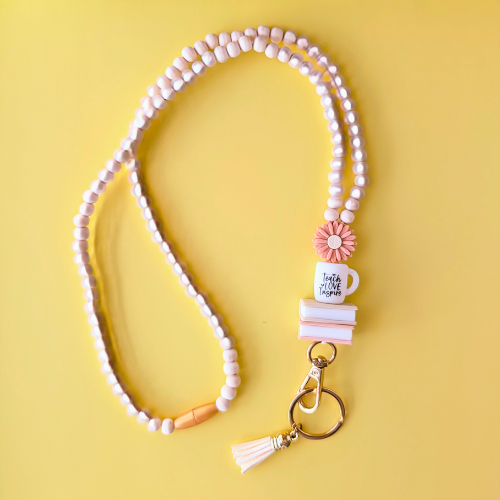 Beaded keychain with a mug charm on a yellow background
