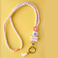 Beaded keychain with decorative elements on a yellow background