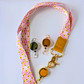Pink lanyard with gold badge holders on a white background
