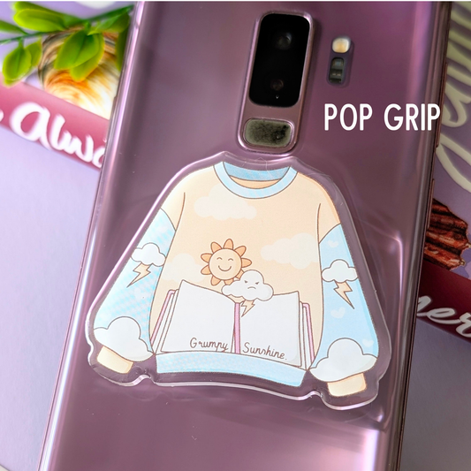 Phone case with cartoon design and 'Pop Grip' text on a blurred background