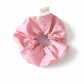 Pink scrunchie with a brand tag on a white background