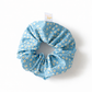 Blue scrunchie with yellow floral pattern on a white background
