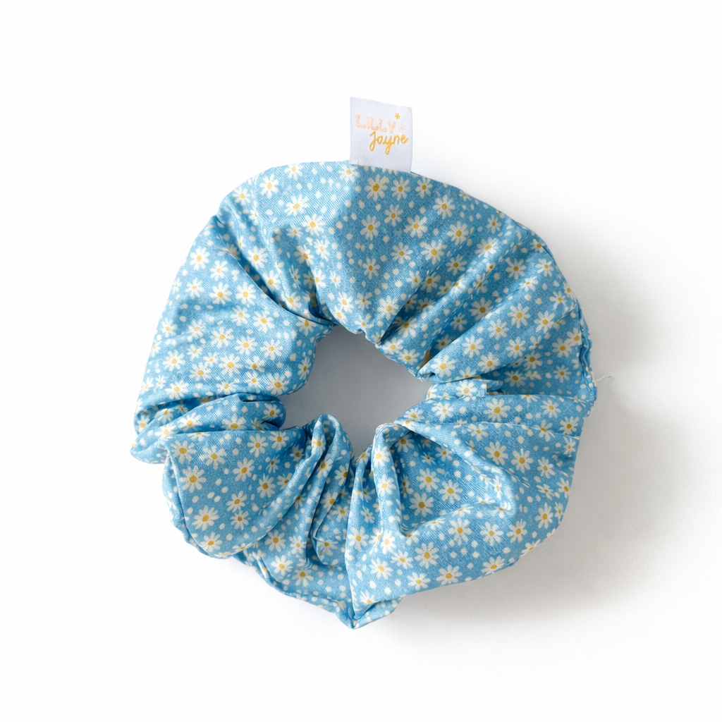 Blue scrunchie with yellow floral pattern on a white background