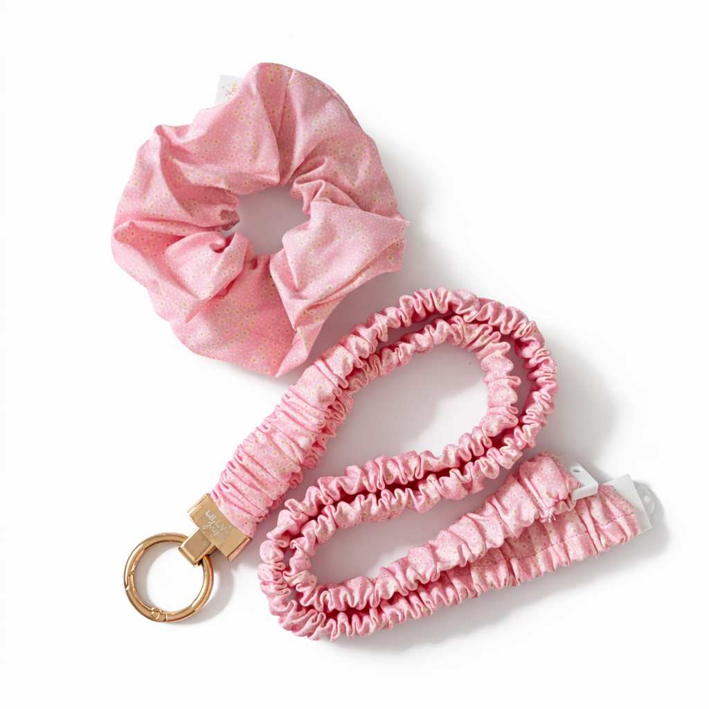 Pink scrunchie and pink scrunchie lanyard with gold clip on a white background