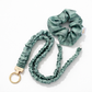 Set of green scrunchies with a keychain on a white background