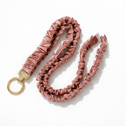 milk chocolate scrunchie-style keychain with a gold ring on a white background