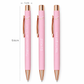 Three pink pens with rose gold accents and motivational phrases, shown with a measurement scale.