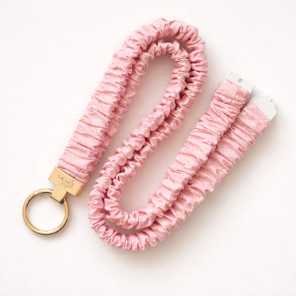 Pink textured keychain with gold clasp on a white background