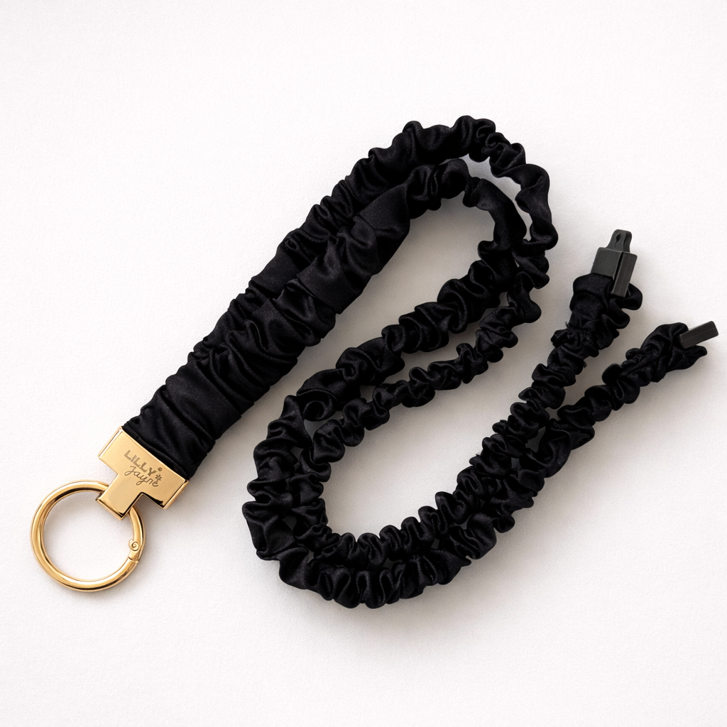 Black scrunchie keychain with gold clasp on a white background
