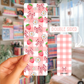 Double-sided pink patterned card held by a hand with a blurred bookshelf background