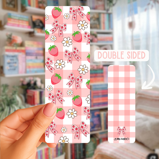 Double-sided pink patterned card held by a hand with a blurred bookshelf background