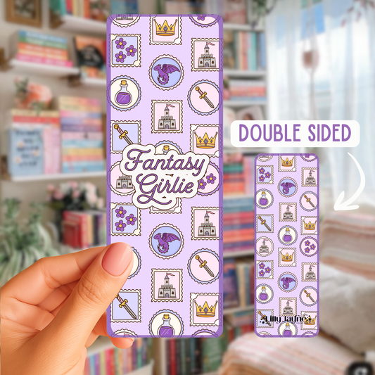 Hand holding a double-sided phone case with 'Fantasy Girlie' design, showing both sides against a blurred bookshelf background.