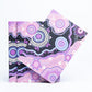 Folded fabric with purple and black pattern on a white background - aboriginal art