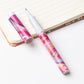 Two colorful pens on a notebook with a white background