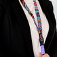 Person holding a colorful lanyard with a black blazer and white shirt.