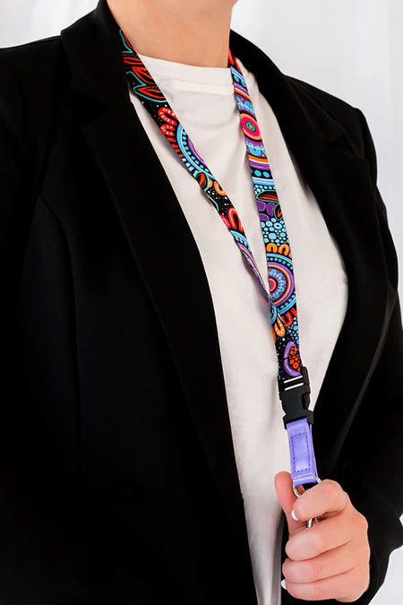 Person holding a colorful lanyard with a black blazer and white shirt.