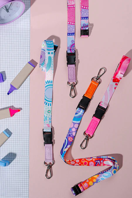 Colorful lanyards with keychains on a pink background