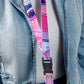 Person wearing a colorful lanyard with a black clip on a denim jacket.