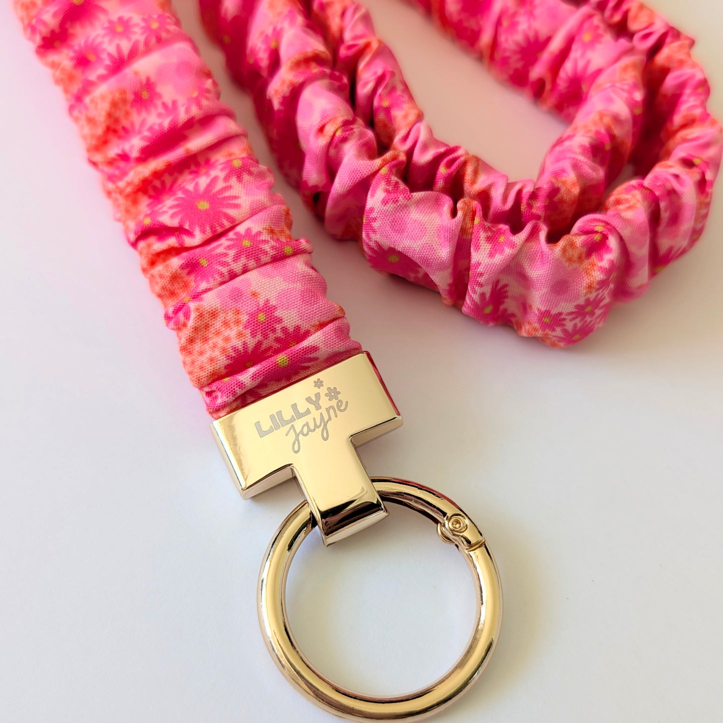 Pink scrunchie keychain with gold clasp on a white background