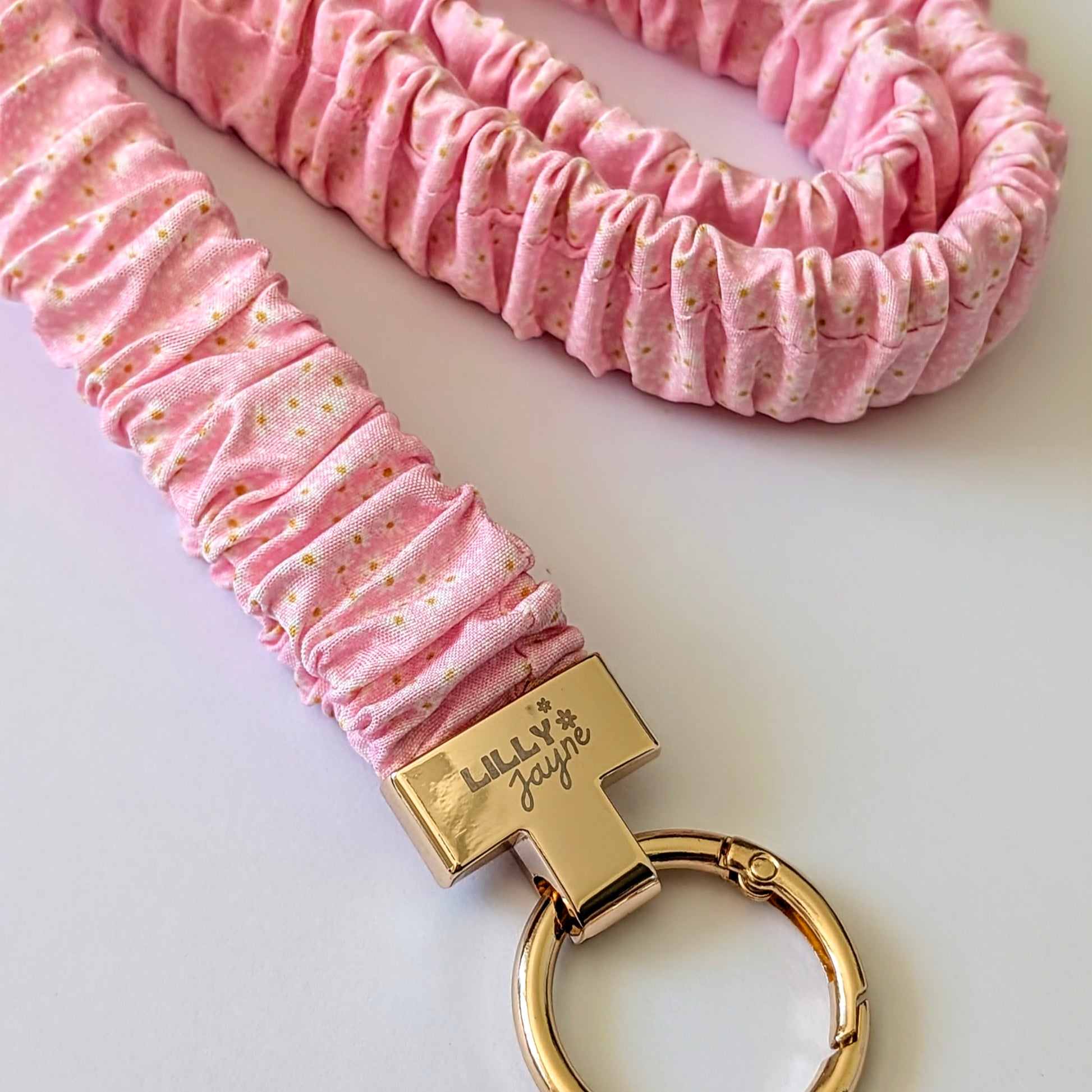 Pink scrunchie keychain with gold keyring and 'Lilly Fayre' branding on a light background