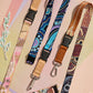 Three colorful lanyards with patterned designs on a pastel background