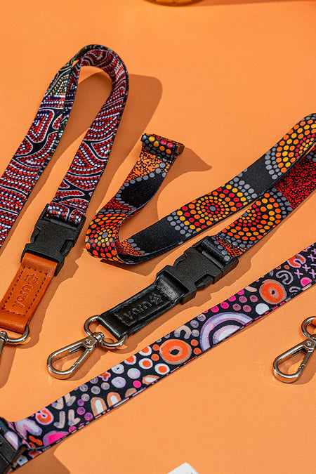 Three colorful lanyards with patterned designs on an orange background