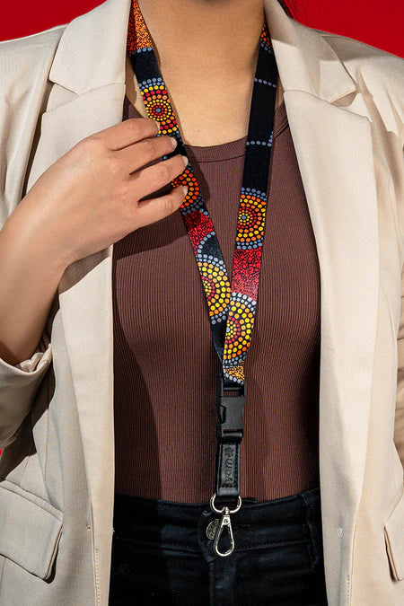 Person wearing a colorful beaded lanyard with a red background