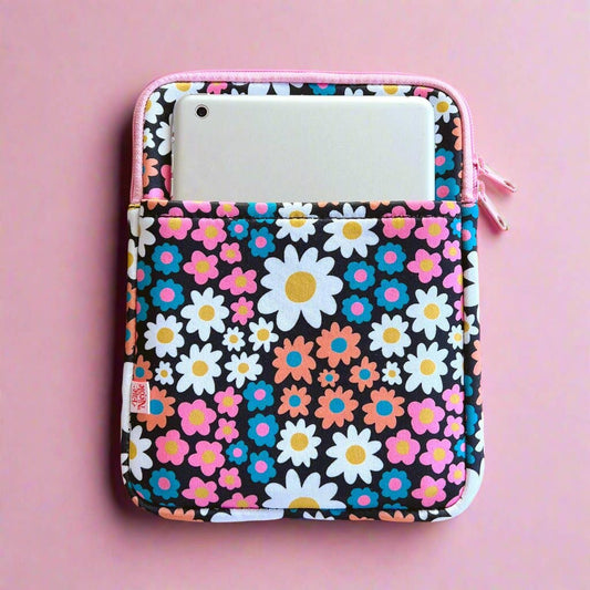 Floral patterned pouch with a white phone inside on a pink background