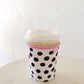 Stack of cups in a polka dot sleeve on a white surface