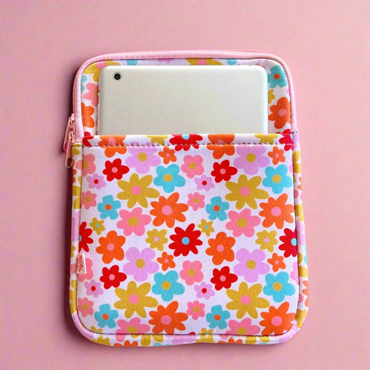 Floral patterned pouch with a phone inside on a pink background