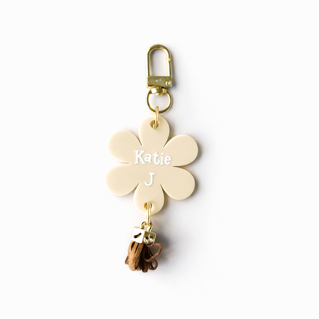 Flower-shaped keychain with 'Katie' and a heart charm on a white background