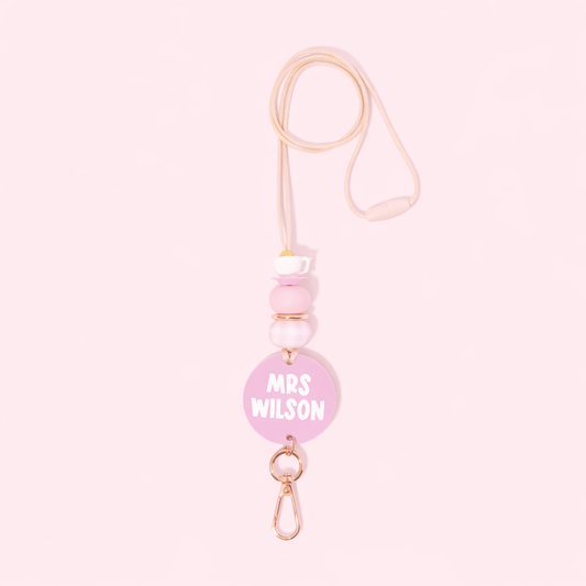 Pink badge holder with 'MRS WILSON' text on a light pink background