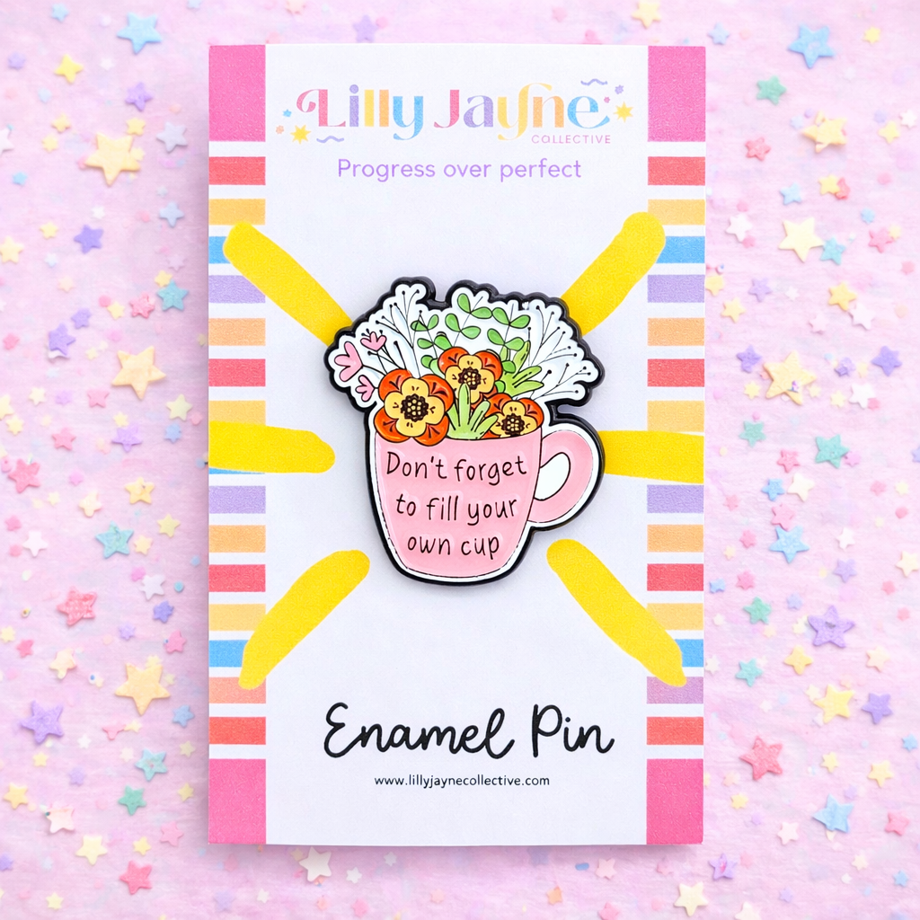 Enamel pin with floral design and motivational quote on a colorful background, branded by Lilly Jayne Collective.