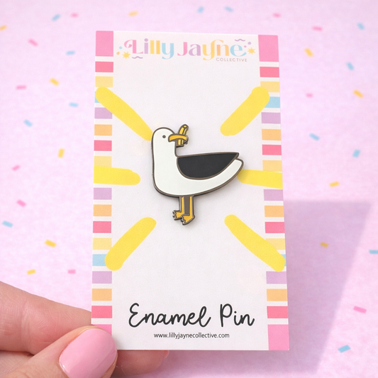 Enamel pin on a card with 'Lilly Jayne' branding against a colorful background