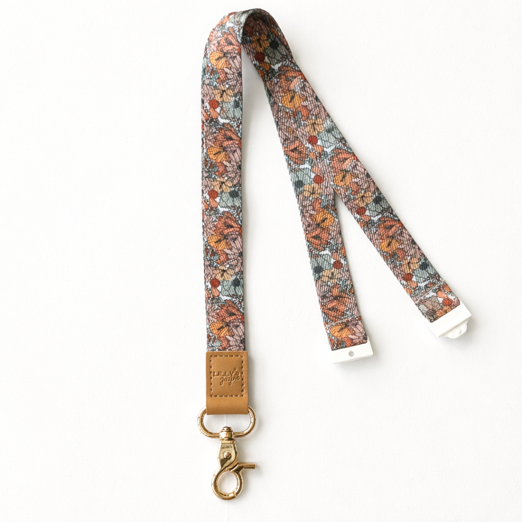 Floral patterned lanyard with a leather tag on a white background