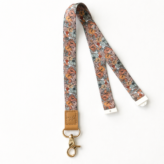 Floral patterned lanyard with a leather tag on a white background