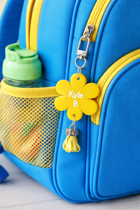 Blue backpack with yellow flower-shaped name tag and water bottle