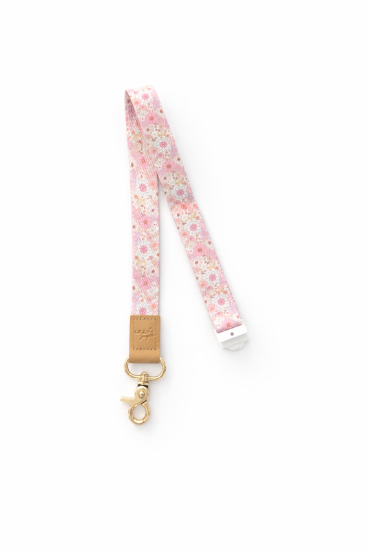 Floral patterned lanyard with a gold clip on a white background