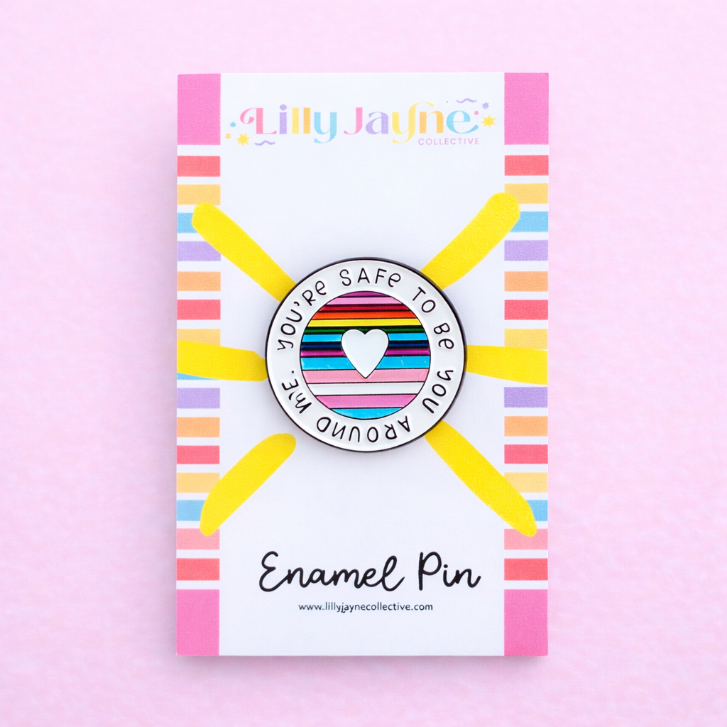 Lilly Jayne enamel pin packaging with a rainbow design on a pink background