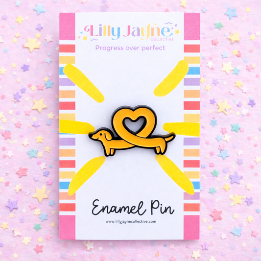 Enamel pin with a heart and dog design on a colorful card with 'Lilly Jayne Collective' branding.